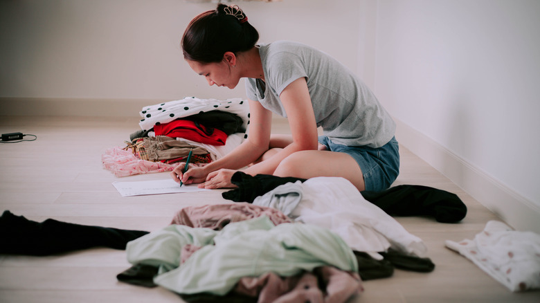 woman noting inventory of clothes