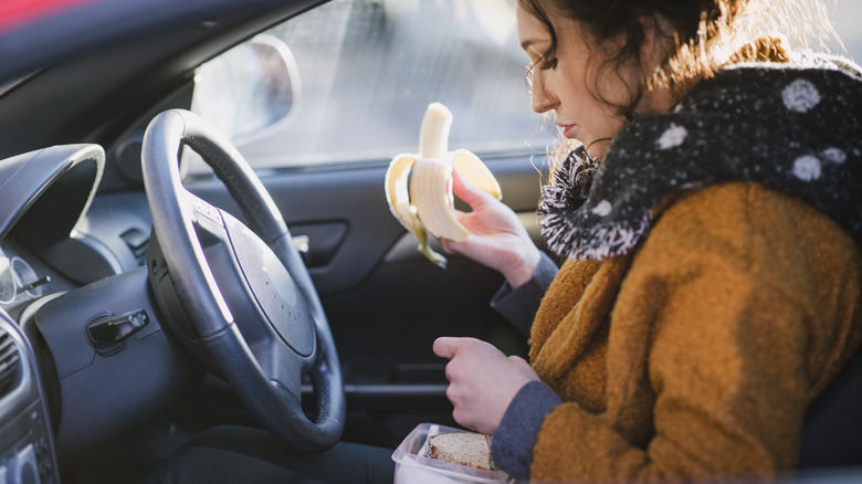 Woman eating lunch in car 