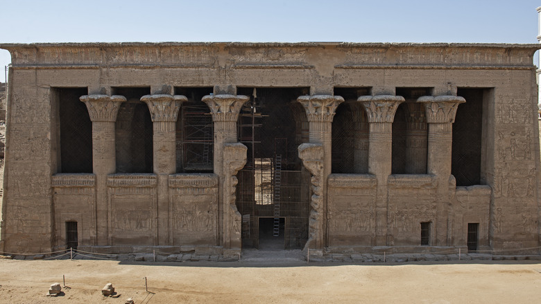 Exterior of the Temple of Esna, with its stone pillars and ornate carvings.