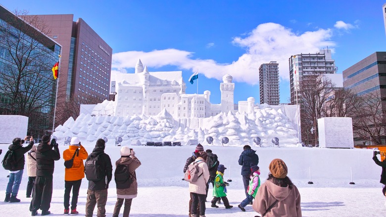 Tourists photograph an ice sculpture in Sapporo