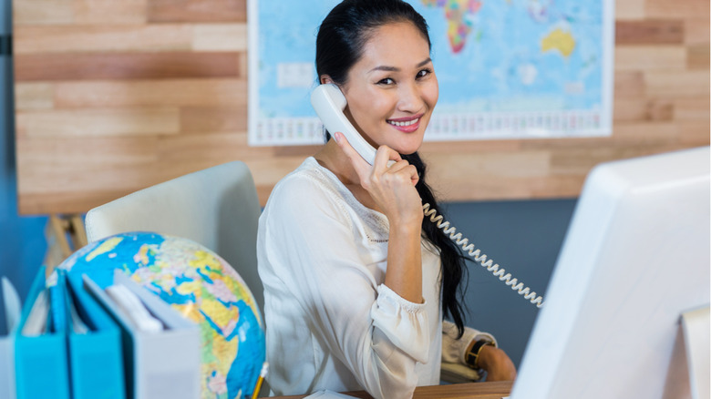Smiling travel agent on phone