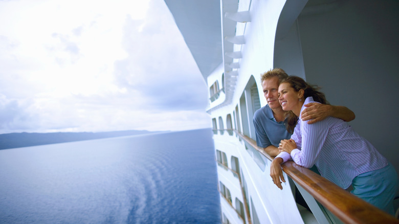 a couple looking at water on cruise ship balcony