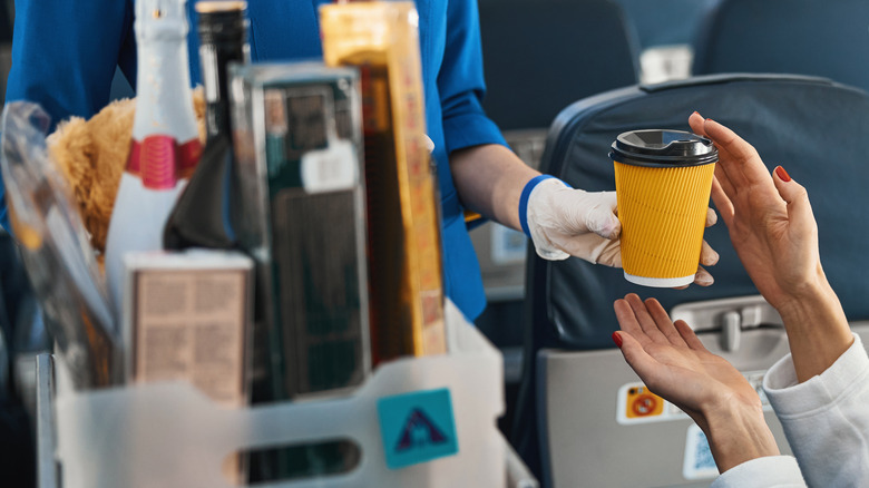 Flight attendant holding coffee