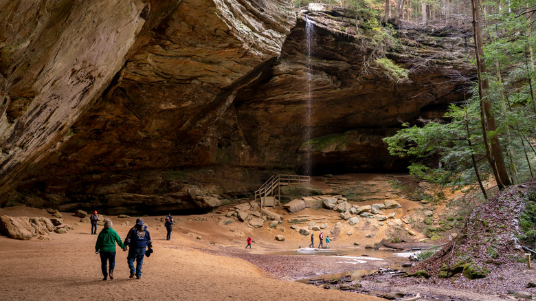 visitors walking through massive cave