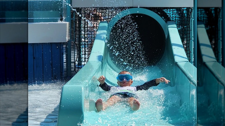 Young child goes down a waterslide