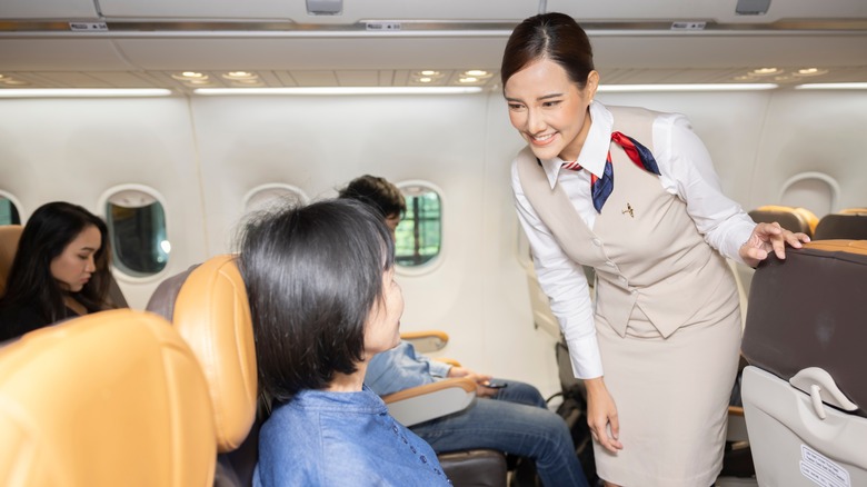 flight attendant speaking with passenger