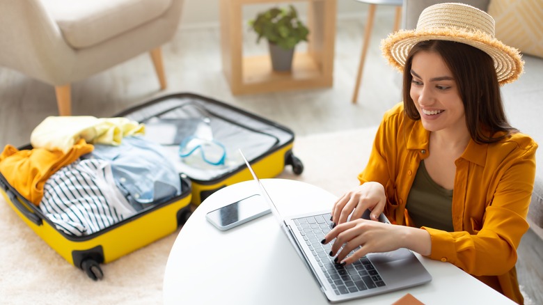 Woman with laptop and suitcase