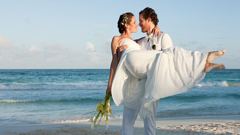 couple on beach in wedding clothes