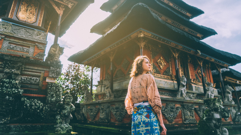 A woman walking a Balinese temple