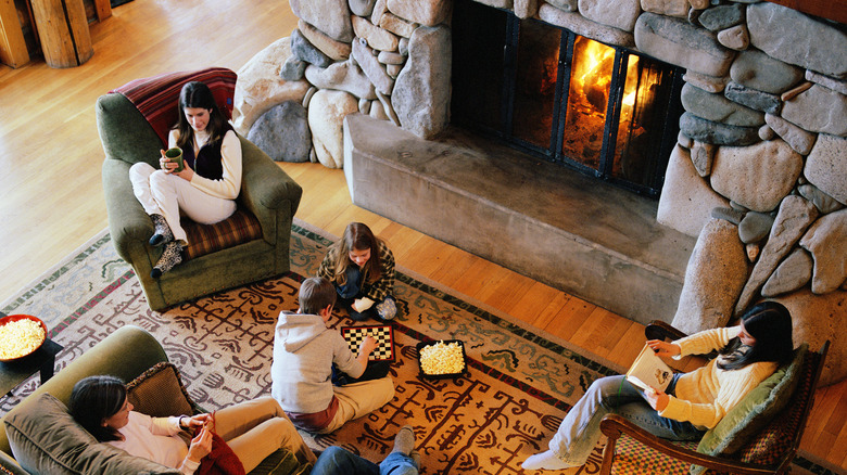 family relaxes by a fireplace