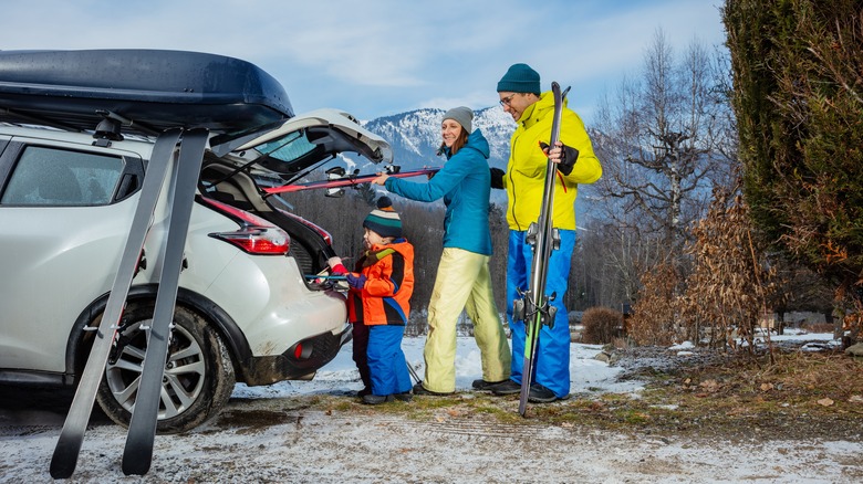 Family loads skis into car