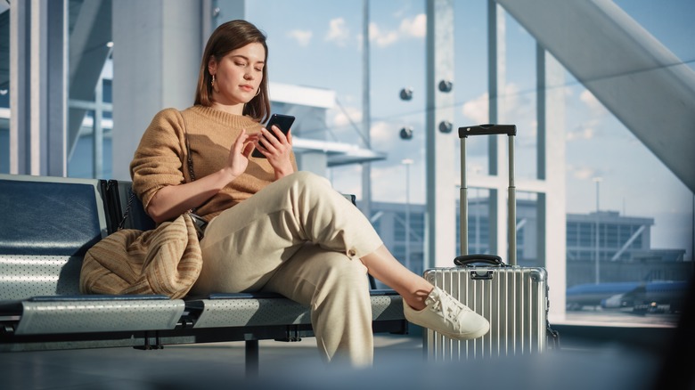 Passenger using phone at airport