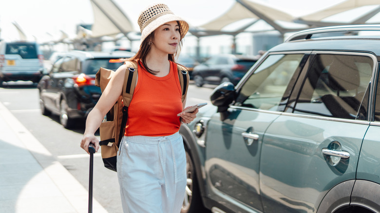 Woman near car holding phone