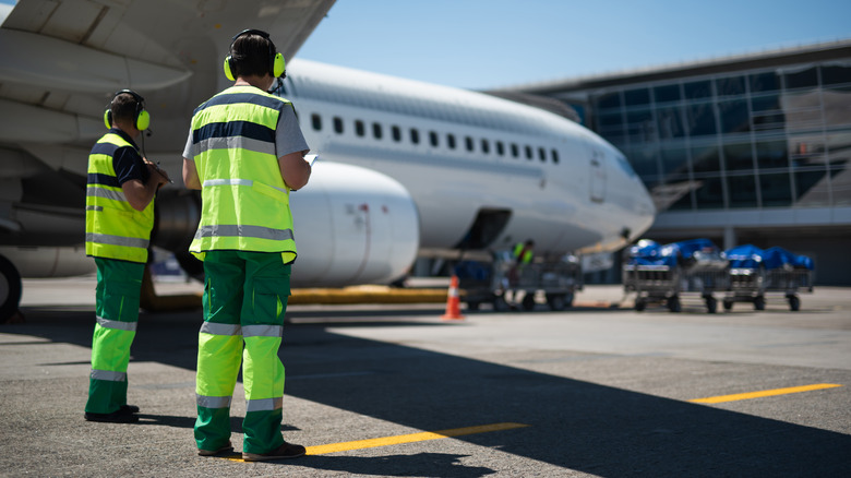 airport staff on the tarmac by a plane