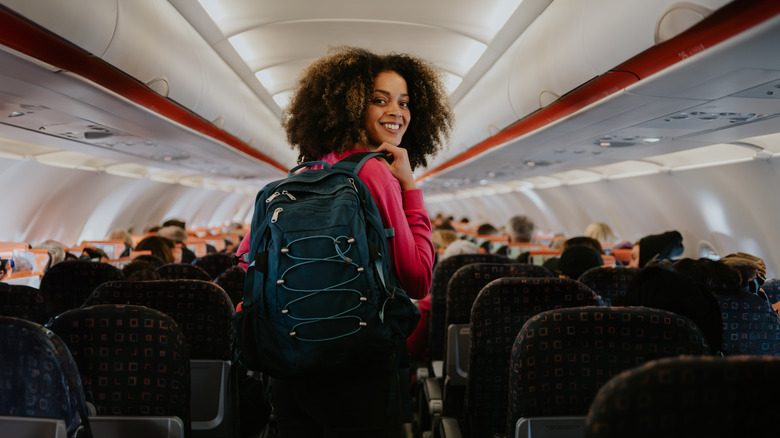 traveler walking in airplane aisle