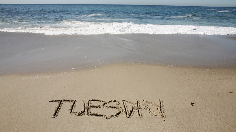 Tuesday written in beach sand