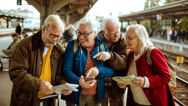 Travelers pointing and looking at maps