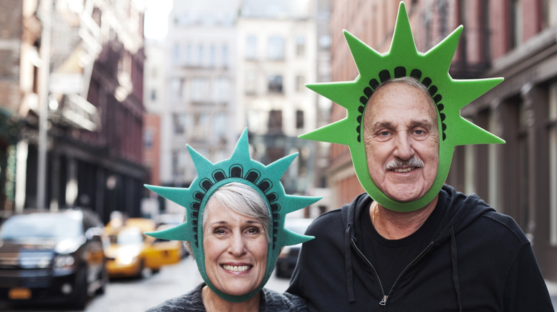 Tourist couple wearing Statue of Liberty crowns.