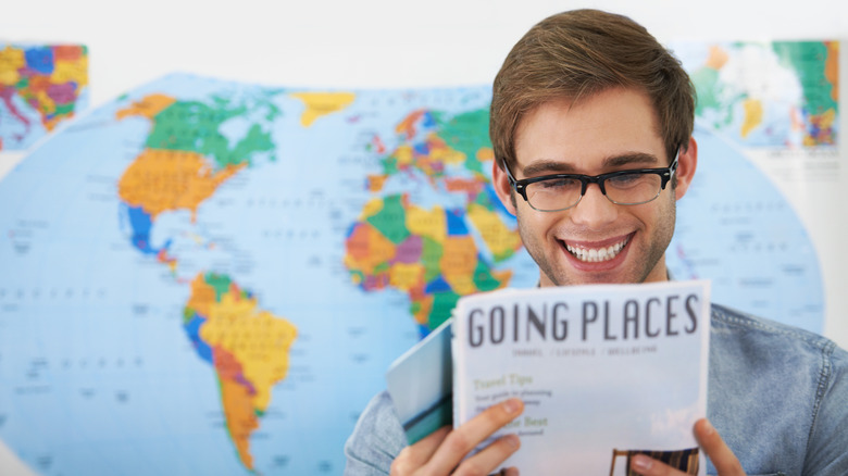 Man reading travel materials before a trip