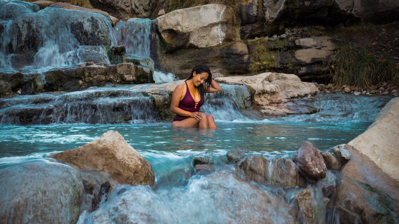 woman in pool near waterfall