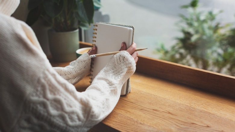 woman in cafe with pencil and paper