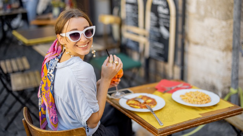 woman drinking wine at restaurant with sunglasses on