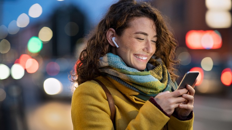 person smiling looking at phone