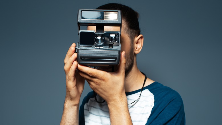 Man using Polaroid camera