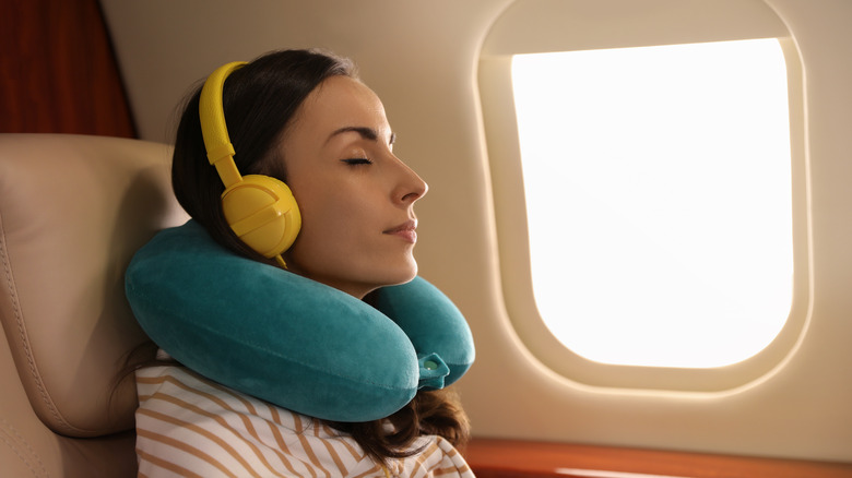 Woman wearing headphones on plane