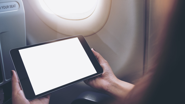 Person using iPad on plane
