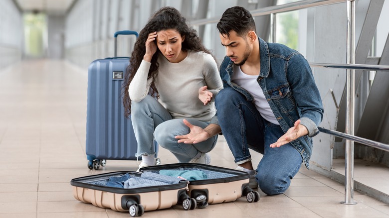 stressed couple with open suitcase