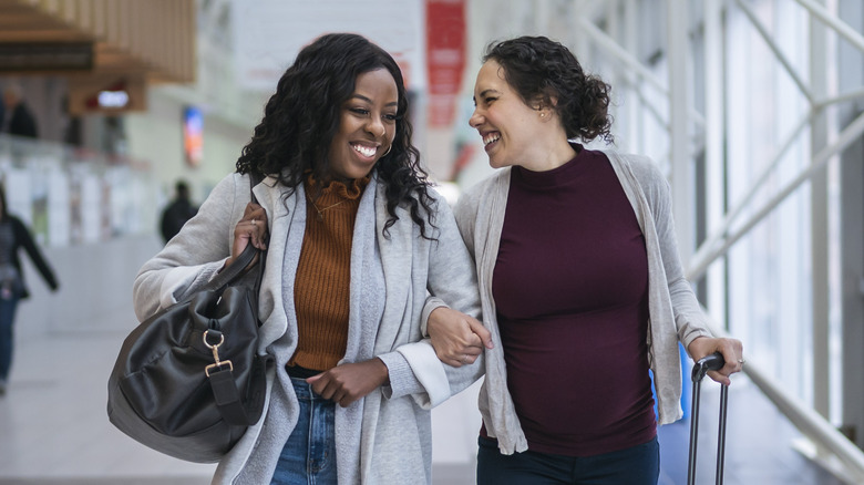 two women laughing in airport