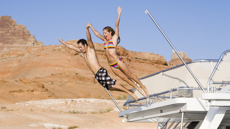 Couple jumping off boat on Lake Powell