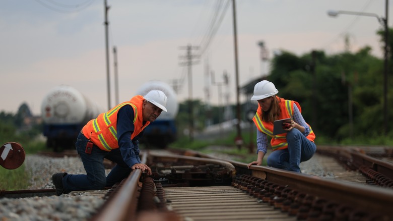 Workers examine tracks on a railroad line