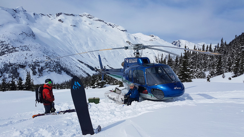 Helicopter beside skier