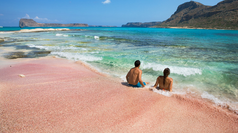 two people on pink sand in Balos