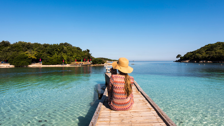 Woman sitting on Ksamil boardwalk