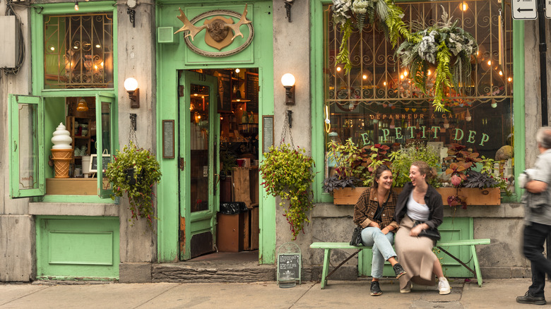 two women laugh by cafe