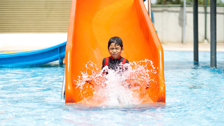 Child sliding into swimming pool