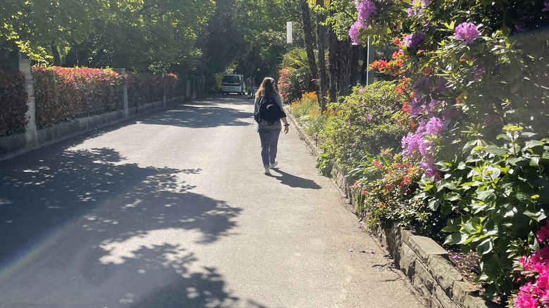 woman walks along Chemin Fleuri promenade