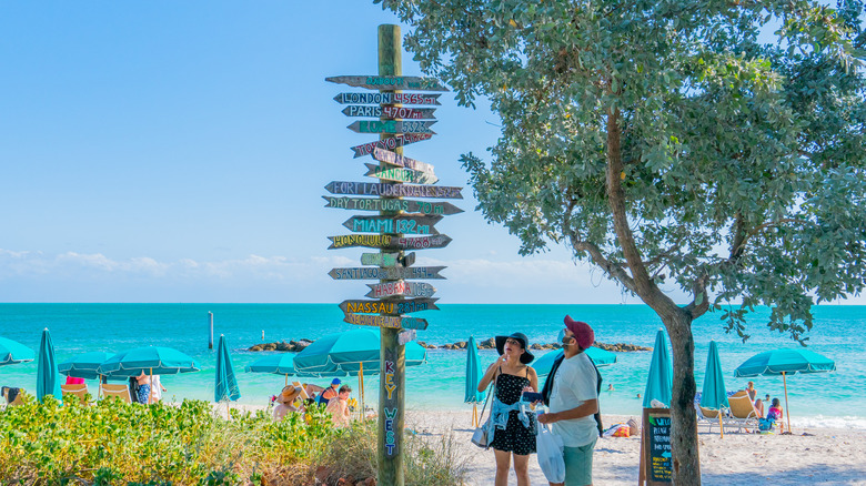 Couple looking at signposts in Key West
