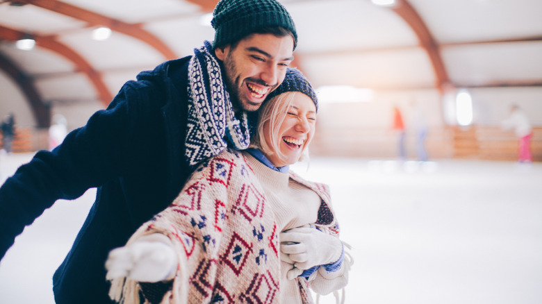 Laughing couple ice skating