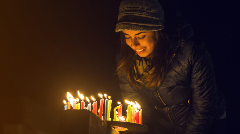 Woman lighting colorful candles