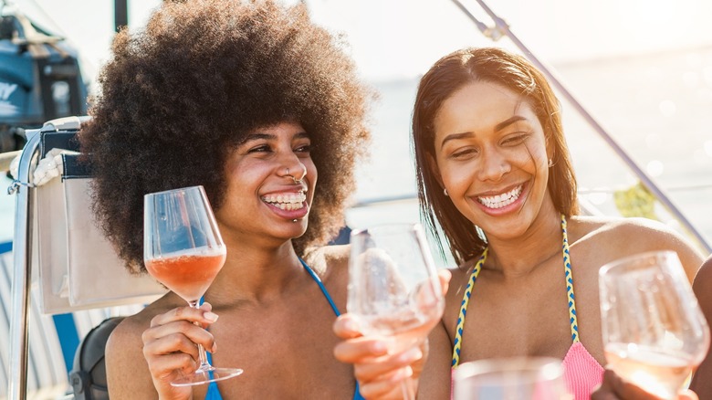 Happy friends drinking on ship