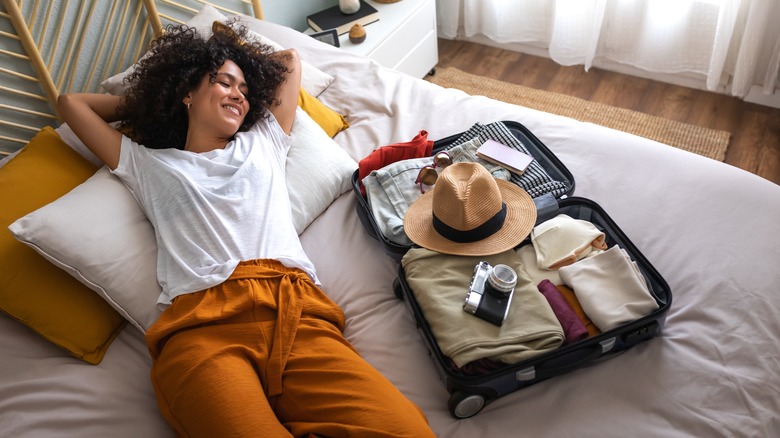 woman on bed with suitcase