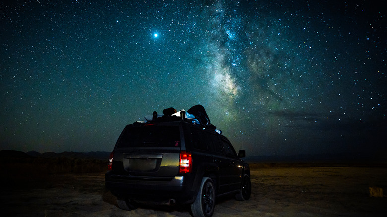 Man stargazing on car