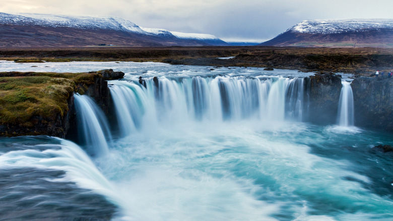 Powerful Goðafoss waterfall with mountains behind