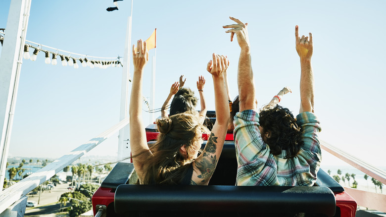 Parkgoers riding roller coaster