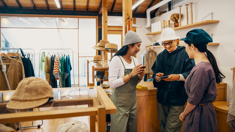 People looking at phones in clothing store