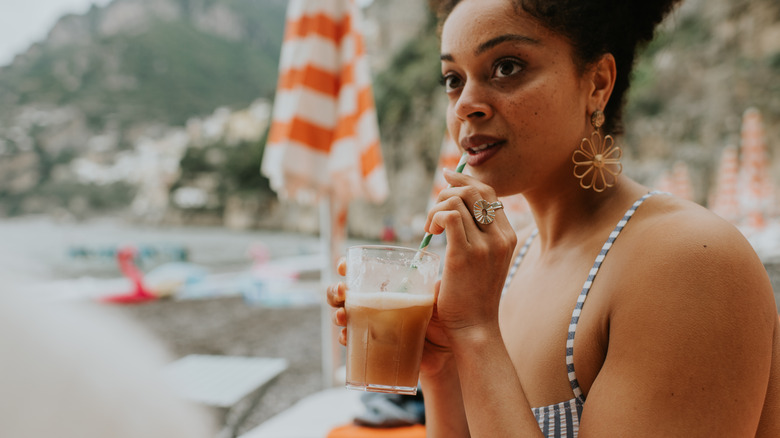 Traveler enjoying drink on Italian beach